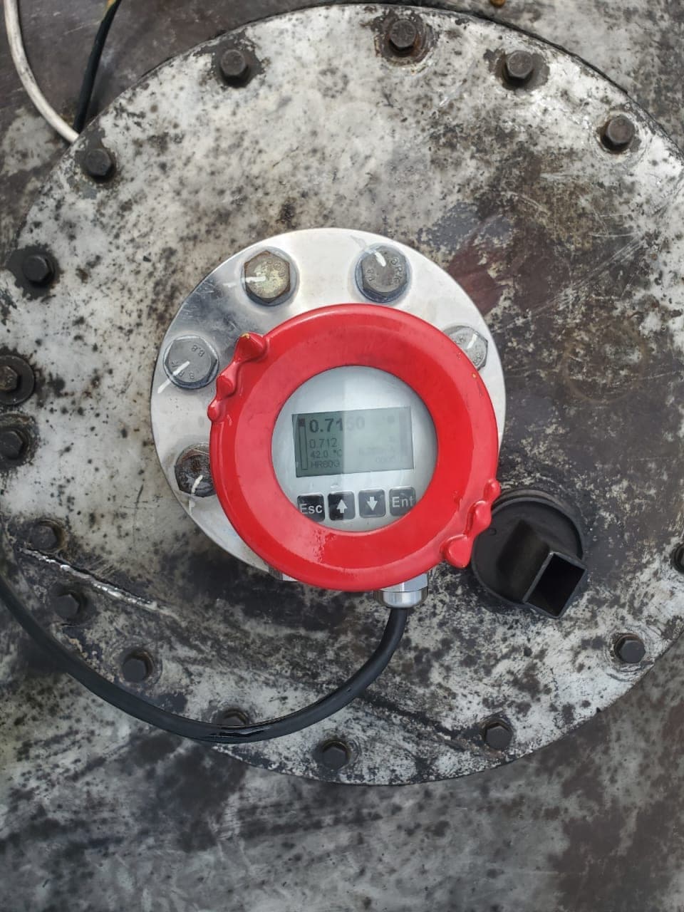 The radar gauge head on a tank manway, displaying the measured distance to the fuel surface