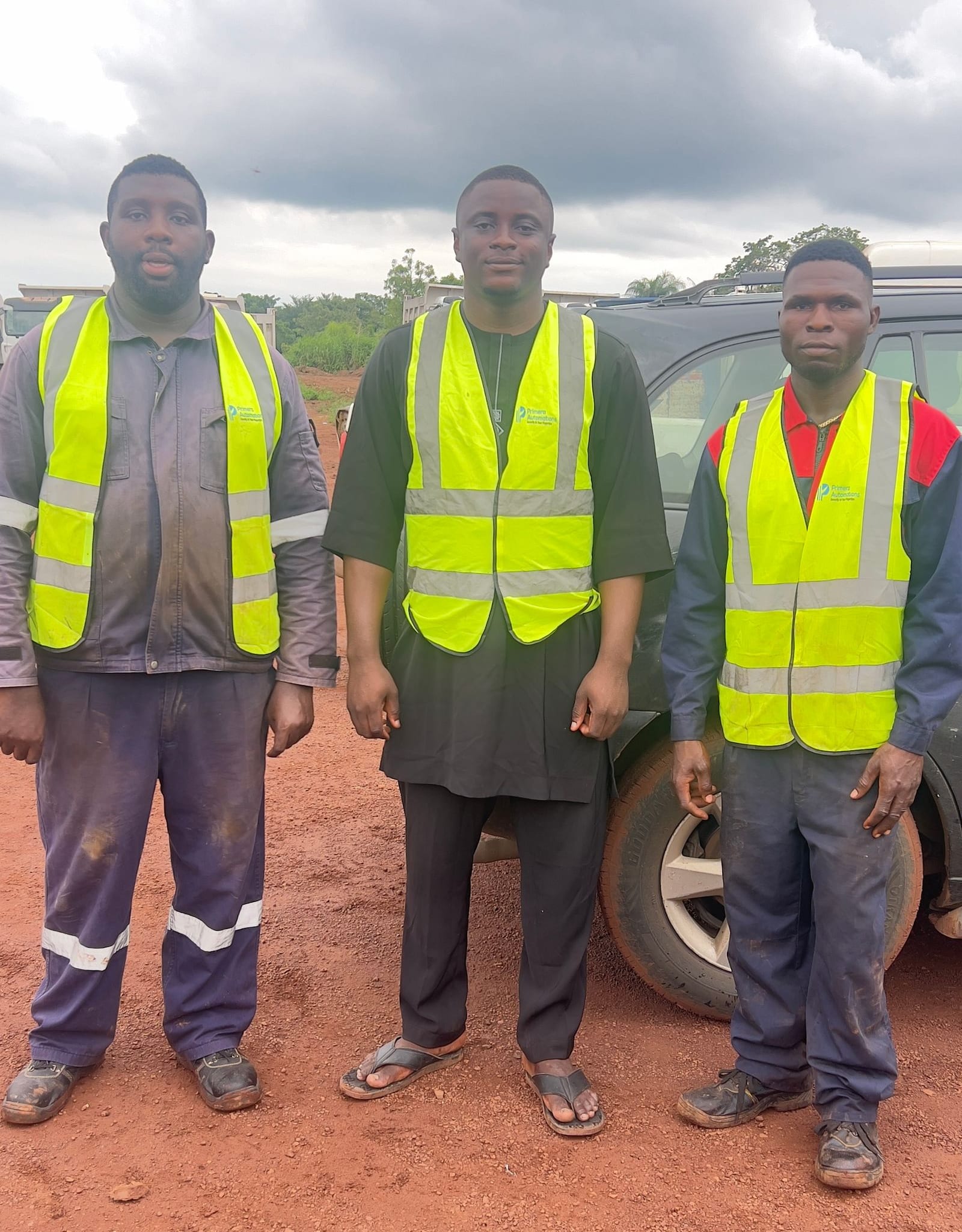 Three Primera Automations technicians in branded hi-vis at a customer's yard